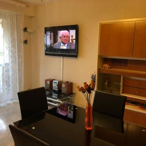 uma sala de estar com uma mesa e uma televisão na parede em Le Vina del Mar Bloc B em Menton