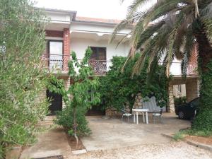 ein Haus mit einem Tisch und Stühlen im Innenhof in der Unterkunft Apartman Zlatko in Zadar