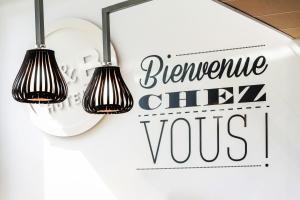 貝爾福的住宿－B&B HOTEL Belfort Bessoncourt，挂在墙上的两盏灯,上面有写着令人讨厌的厨师的标语