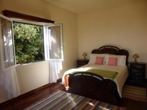 ein Schlafzimmer mit einem Bett und einem großen Fenster in der Unterkunft Ocean Paradise BEACH VILLA Paul do Mar in Paul do Mar