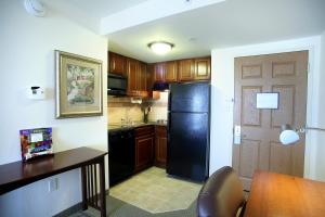a kitchen with a black refrigerator and a table at Staybridge Suites Indianapolis Downtown-Convention Center, an IHG Hotel in Indianapolis