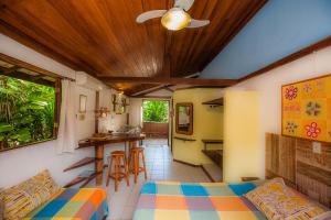 a room with a bed and a kitchen with a table at Shanti House Apart in Praia do Forte