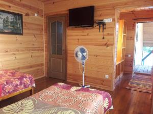 a room with a fan in a log cabin at Лазурний берег in Pulemets