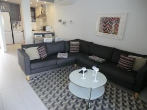 a living room with a black couch and a table at Casas Holiday - Oasis Beach in Playas de Orihuela