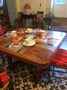 een houten tafel met eten erop bij le Logis du Plessis in Chaniers +30 foto's