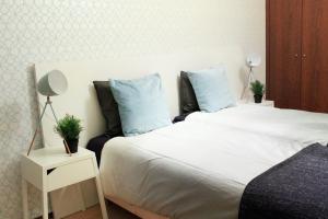 1 dormitorio con 1 cama blanca grande con almohadas azules en Caldas do Gerês Apartment, en Gerês