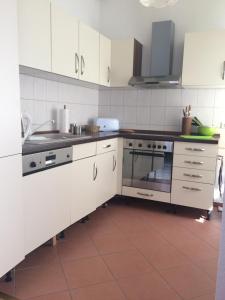 a kitchen with white cabinets and a stove at Ferienwohnung Sandow in Cottbus