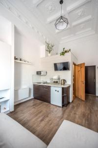 Il comprend une cuisine avec des murs blancs et du parquet. dans l'établissement Cozy studio in the heart of the city, à Odessa