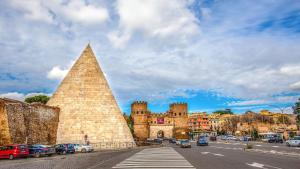 a large castle with cars parked in front of it at Sweet Piramide Bed and Breakfast in Rome