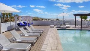 a swimming pool with lounge chairs and a swing at Barefoot Beach Club in St. Pete Beach