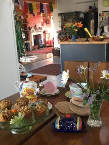 une table avec des assiettes de nourriture et un vase de fleurs dans l'établissement Heavenly Retreat, à Corsham