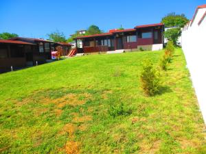 a grassy yard with houses in the background at Дървени къщички - Лион in Sinemorets