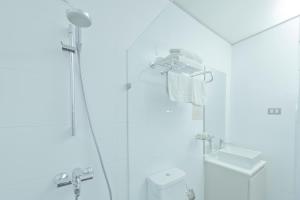 a bathroom with a shower, sink, and toilet at Hotel Campanario Del Mar in La Serena
