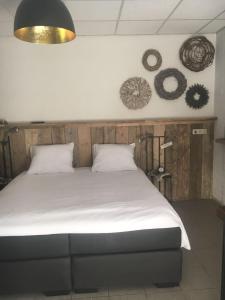 a bed with two pillows and two mirrors on the wall at Hof van donzel in Nistelrode