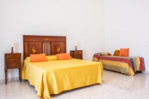 ソレントにあるOrsola Maisonのベッドルーム1室(黄色のシーツとオレンジの枕が備わるベッド2台付)