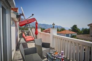 un balcón con 2 sillas y una mesa con comida. en Luxury loft "Royal Dominus", en Orebić