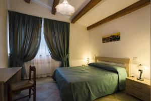 um quarto com uma cama, uma secretária e uma janela em San Paterno B&B em Rapolano Terme