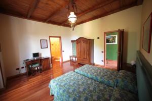 a bedroom with a bed and a desk in it at Hotel Valganna - Tre Risotti in Valganna