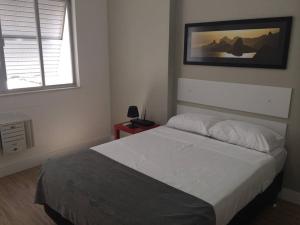 1 dormitorio con 1 cama y una foto en la pared en apartamento luxo copacabana, en Río de Janeiro