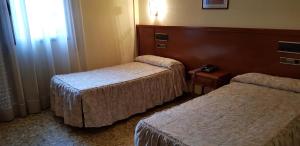 リェイダにあるHotel Reina Isabelのベッドが2つと窓があるホテルの部屋 +50枚の写真