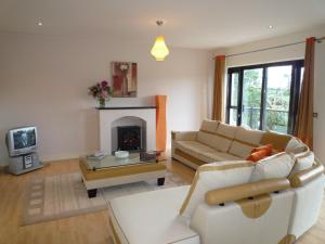 ein Wohnzimmer mit einem Sofa und einem Kamin in der Unterkunft Grove Lodge Holiday Homes in Killorglin