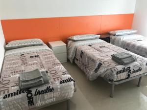 Una habitación con tres camas con mantas encima en B&B Appartamento Anna, en Bolonia