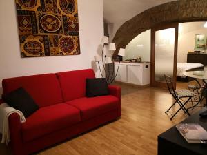 un soggiorno con divano rosso e una cucina di L' Arcata a Montesanto a Napoli
