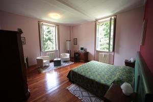 1 dormitorio con 1 cama y 2 ventanas en Hotel Valganna - Tre Risotti, en Valganna