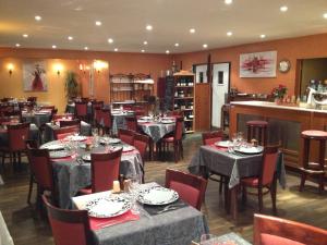 a restaurant with tables and chairs in a room at Hôtel Le Forestia in Pannes