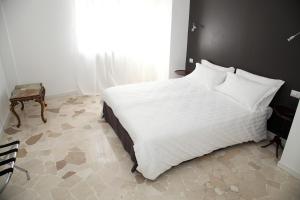 um quarto com uma cama branca e uma grande janela em Torregiardino em Abbiategrasso