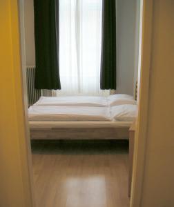 a bed in a room with a window at Pension Schottentor in Vienna