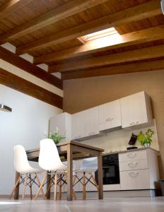 - une cuisine avec une table en bois et des chaises blanches dans l'établissement Downtown in Parma, à Parme 9 autres photos