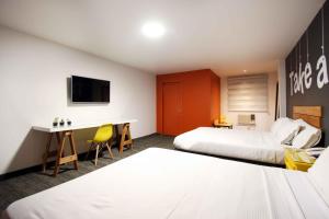 Cette chambre comprend deux lits et un bureau. dans l'établissement B my Hotel, à Tijuana