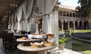 a restaurant with tables, chairs, and umbrellas at Monasterio, A Belmond Hotel, Cusco in Cusco