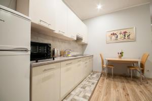 a kitchen with white cabinets and a table at Wonderful flat on city center (Mukachivska 4/15) in Uzhhorod +4 photos