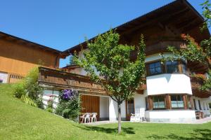 una casa con un árbol delante de ella en Haus Moosanger, en Oberau