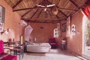 a living room with a bed and a ceiling at Le Karite Bleu in Ouagadougou