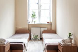 two beds in a room with a mirror and a window at Hello Apartments Ogarna in Gdańsk