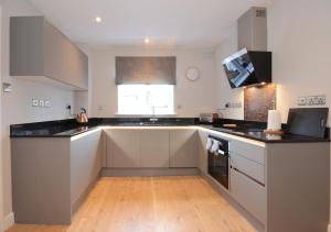 a kitchen with white cabinets and black counter tops at Fossgate Luxury Duplex City Centre Apartment with Free Parking in York +12 photos