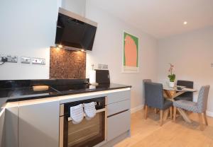 a kitchen with a counter and a table with chairs at Fossgate Luxury Duplex City Centre Apartment in York