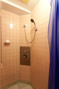 bagno con doccia e tenda blu di Kimi Ryokan a Tokyo