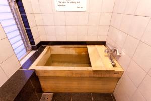 e bagno con vasca e lavandino. di Kimi Ryokan a Tokyo