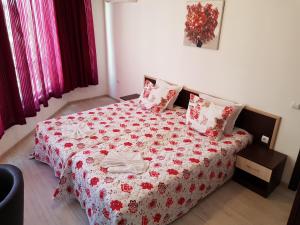 ブルガスにあるFamily Aparthotel Vintegraのベッドルーム1室(ベッド1台、赤と白の毛布付)