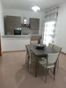 a dining room with a table and chairs and a kitchen at Villa Fiorella in Sciacca