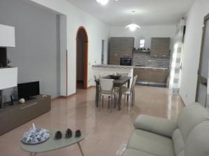 a living room with a couch and a table with chairs at Villa Fiorella in Sciacca