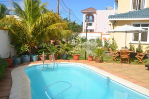 a swimming pool in a yard with a house at Villa Sundara Mauritius in Trou aux Biches