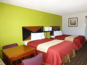 duas camas num quarto de hotel com paredes verdes em Coach Inn - Summerville em Summerville