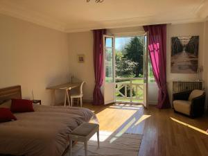 um quarto com uma cama e uma porta de vidro deslizante em La villa rochette em Forges-les-Bains