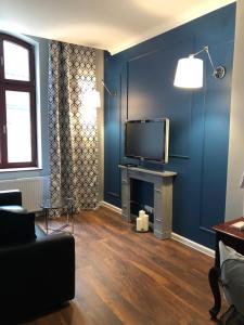 カトヴィツェにあるLivingRoom 1 self Check-in 24hの青い壁にテレビ付きのリビングルーム