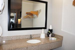 La salle de bains est pourvue d'un lavabo et d'un miroir. dans l'établissement Americas Best Value Inn - Milpitas, à Milpitas